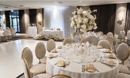 Salle de réception blanche avec centres de table fleuris